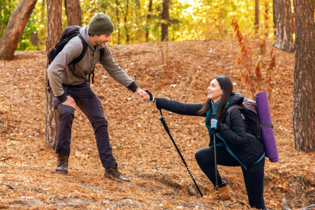 istock Handsome hiker helping his girlfriend uphill in forest 2181199944
