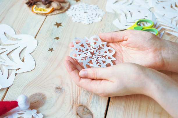 istock A snowflake made from paper with your own hands gracefully decorates a winter interior, adding warmth and a cozy atmosphere 2181199946