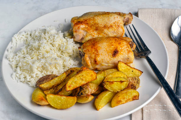 istock chicken thighs  with rice and  potatoe wedges 2181200238