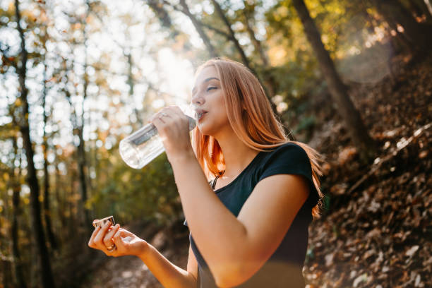 istock Redhead woman drinking water in nature 2181201755