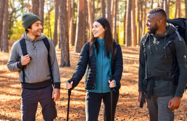 istock International backpackers walking by forest and talking 2181203618