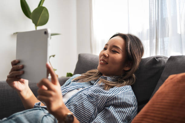 istock Asian woman relaxing at home using a digital tablet 2181212232