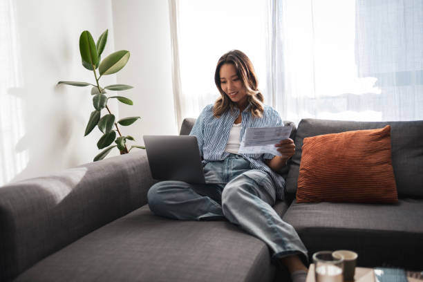 istock Woman working from home on laptop while sitting on a cozy sofa 2181212233