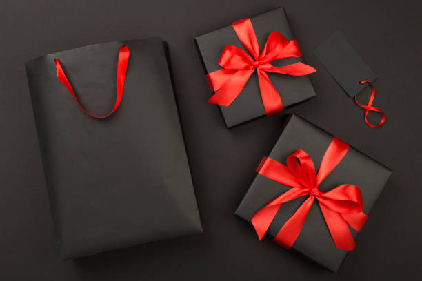 istock Black shopping bag and gift boxes on color background, top view.Black Friday concept 2181212893