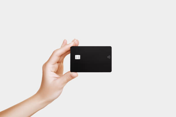 istock female hand holds a black plastic bank card on a grey background 2181216418