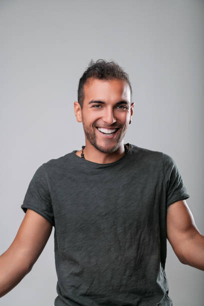 istock Young man smiling and expressing happiness on gray background 2181218214