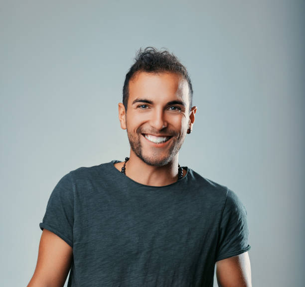 istock Young man smiling and expressing happiness on a gray background 2181218315
