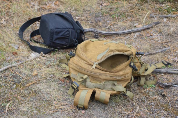 istock brown army backpack and black bag lie on gray ground 2181219876