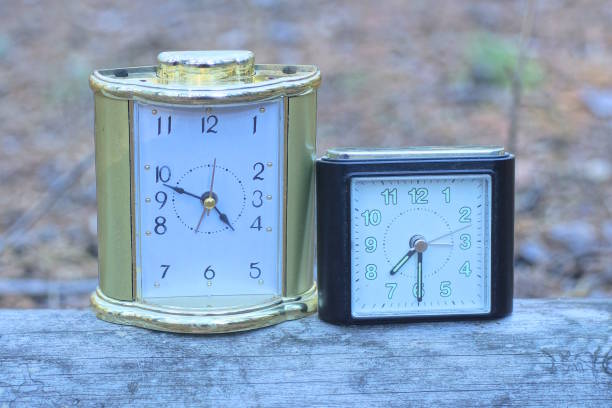 istock two old alarm clocks stand on a gray table 2181220182