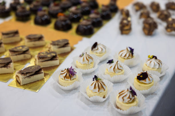 Cake mini with edible flowers, patisserie lemon tart meringue, tiramisu and eclairs. Dark chocolate mousse cakes with strawberry and edible flowers. Soft, decadent, patisserie
