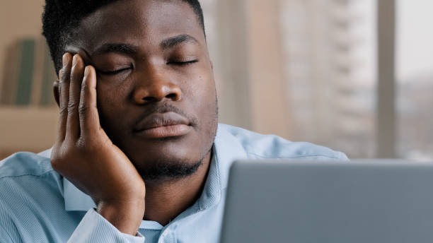 istock Sleepy tired african man office male dreamer businessman has sleeping problem napping rest at desk american lazy student overworked guy in retire closed eyes feeling exhausted after hard computer work 2181229214