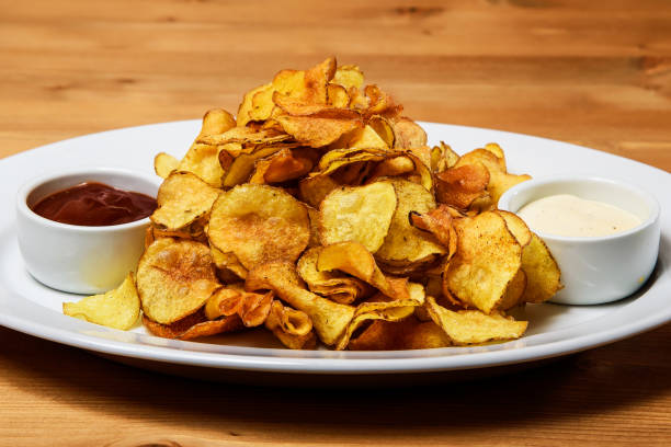 istock Potato chips with sauce on a wooden table. Selective focus. 2181230025