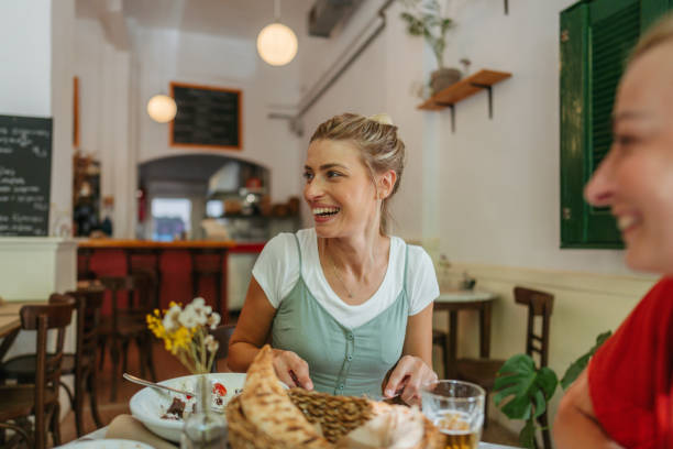 istock Friends are chatting and smiling at a cozy restaurant. 2181231145