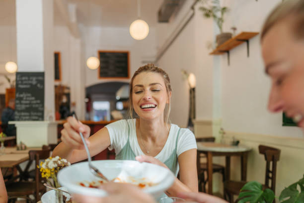 istock Friends are animatedly chatting and smiling at a cozy restaurant. 2181231155