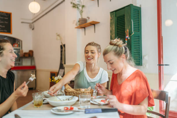 istock Friends are animatedly chatting and smiling at a cozy restaurant. 2181231186