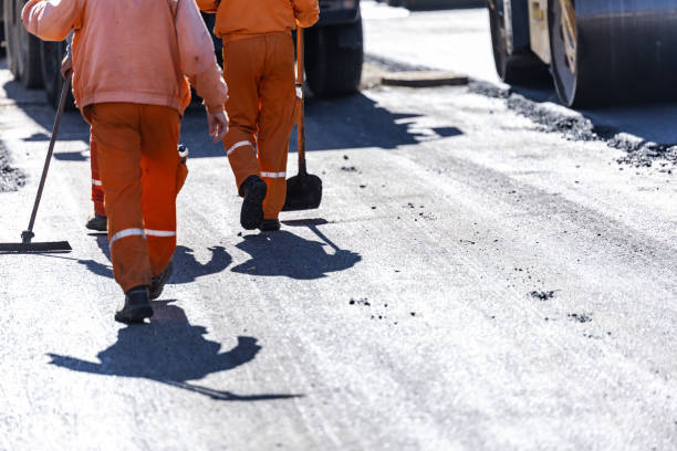 istock Construction workers laying asphalt on a sunny day while preparing a road for repaving in an urban environment 2181233952