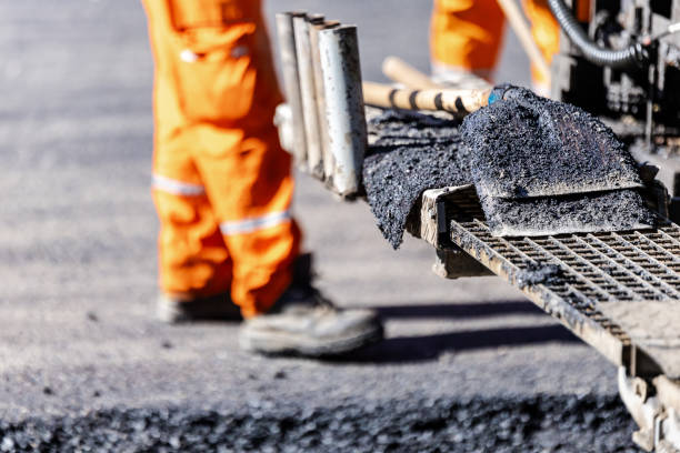 istock Construction worker operating an asphalt paving machine on a roadway in broad daylight, laying down fresh pavement 2181233965