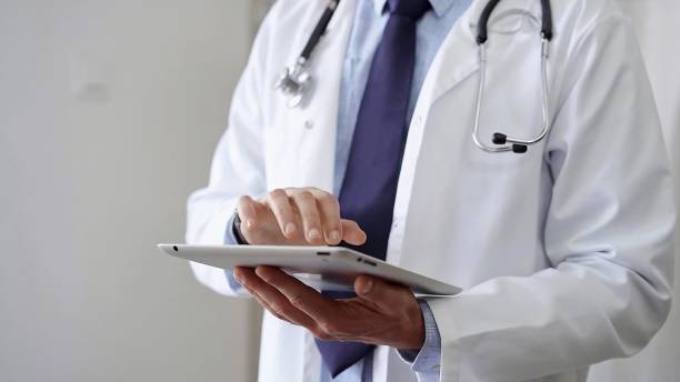istock Doctor man wearing lab coat and stethoscope using tablet computer in hospital. Medicine and science 2181235096