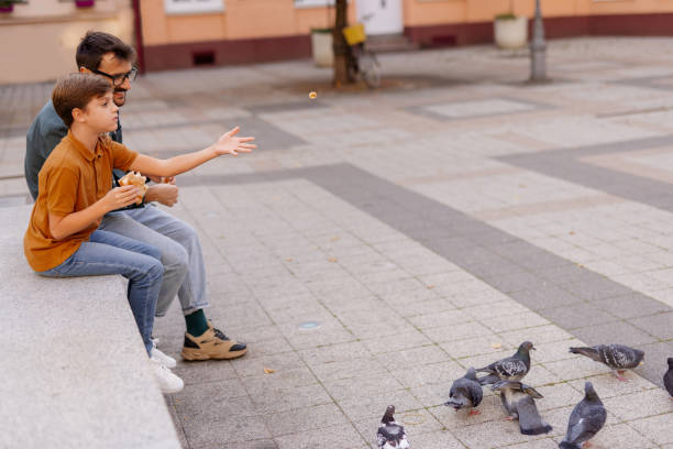 istock Father and Little Boy Feed Pigeons 2181236140