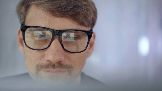 istock Businessman with glasses looking intently obscured partially by a translucent surface of laptop. Business concept 2181236283