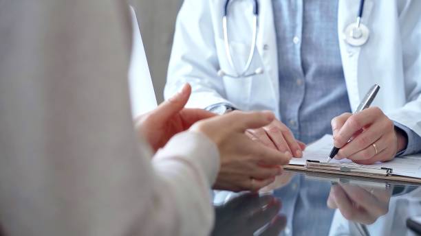 istock Doctor man is making notes while consulting patient with clipboard and a pen in his hand in medical office. Trust concept in Medicine 2181237763