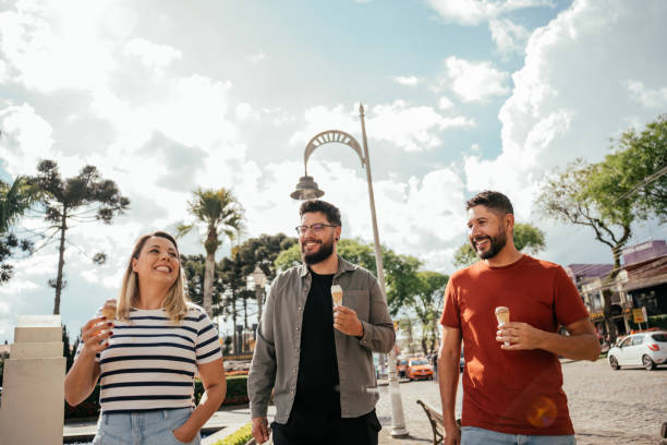 istock Three friends eating ice cream and talking outdoors 2181245622