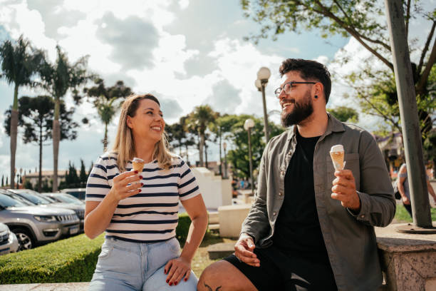 istock Three friends eating ice cream and talking outdoors 2181245627