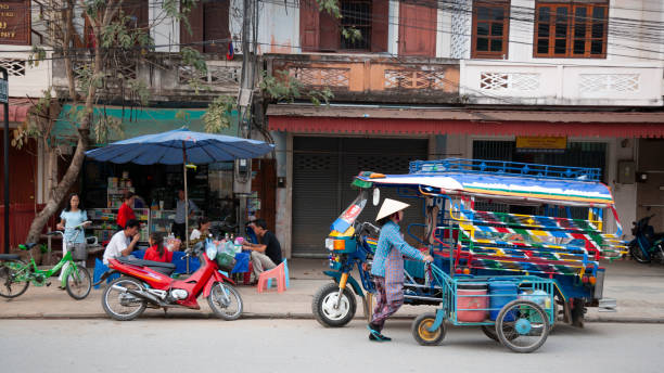 Luang Prabang, Laos - April 8, 2011: Local tuk tuk, people and typical street life activity in Luang Prabang