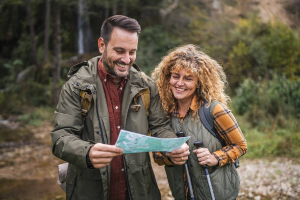 istock hiker couple backpackers explore forest and find route on map 2181249675