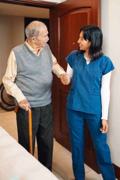 istock Nurse holding hand of an elder man while walking 2181249957