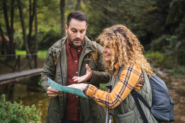 istock worried hiker couple backpackers try to find route on map 2181250088