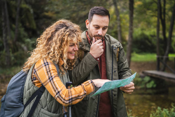 istock worried hiker couple backpackers try to find route on map 2181250265