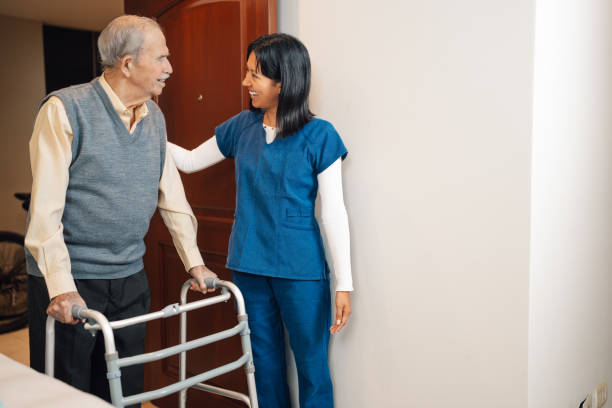 istock Elder man using walker during a nurse visit at home 2181251447