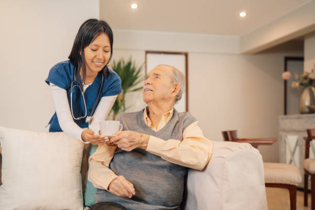 istock Home caregiver serving coffee to an elder man 2181252364