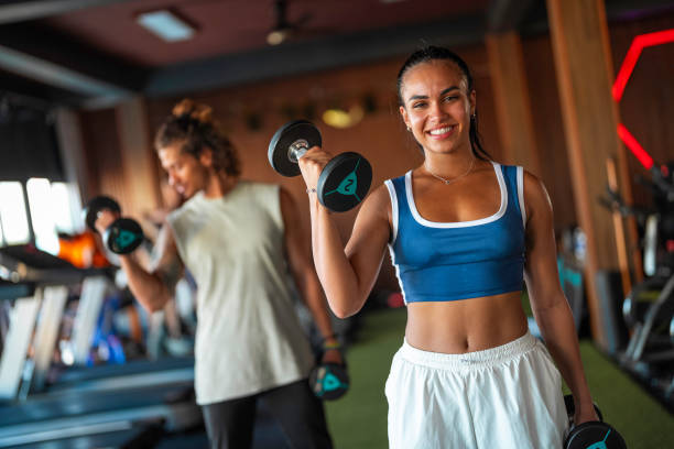 istock Smiling Hispanic Female Lifting Weights In Gym 2181252493