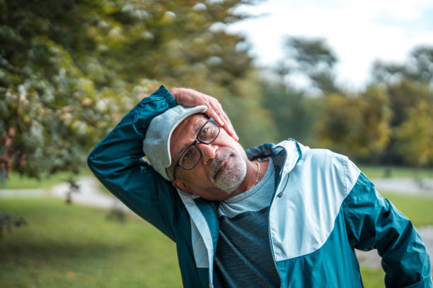 istock Active Senior Asian Male Stretching in Park 2181252895