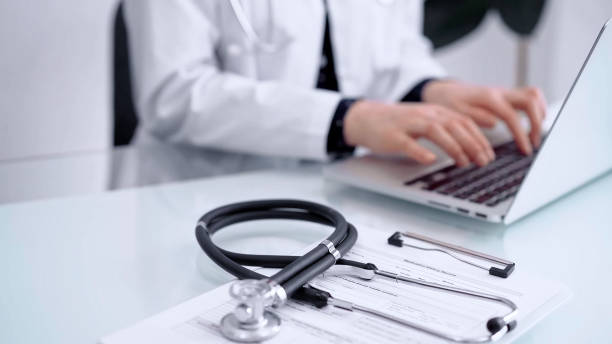 istock Stethoscope is lying on the glass table while doctor woman is working with laptop computer. Medicine and pharmacy concept 2181255559