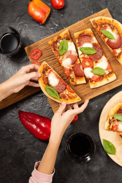 istock Children's hands hold a slice of pepperoni pizza 2181265261