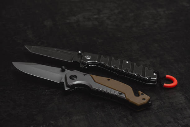 istock Two opened tactical military knives with sharp blade. Tool on dark concrete background. 2181266683