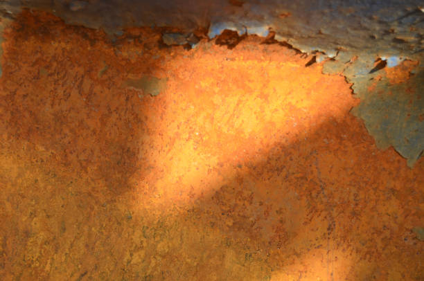 Close up texture of rusty metal and peeling paint in stark lighting