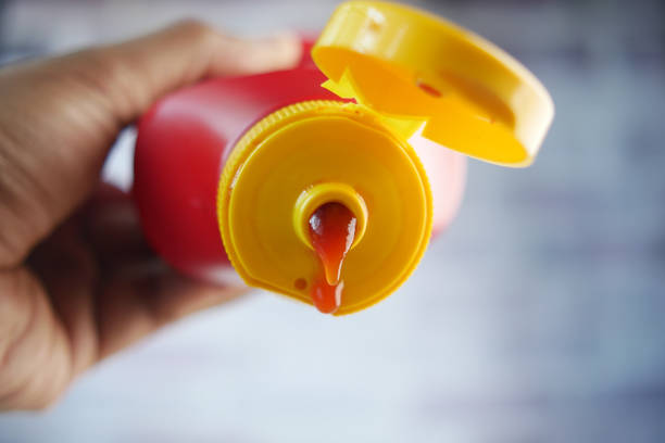 Pouring tasty ketchup from a bottle ,