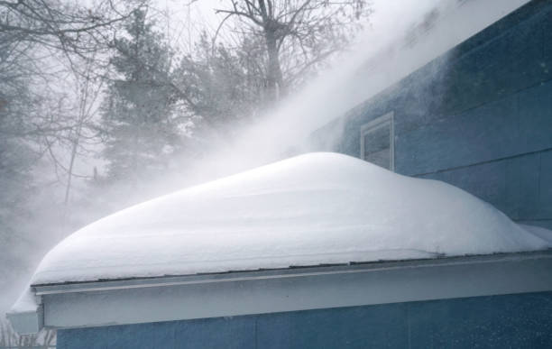 istock Winter wind blowing thick snow on the roof in blizzard 2181284852