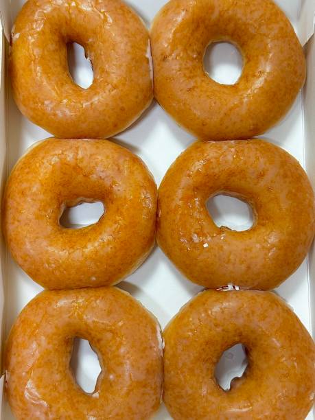 istock A classic glazed donut with a soft, fluffy texture and a sweet, glossy coating. Perfectly balanced between light and sugary, making it an irresistible treat for any time of the day. 2181287583
