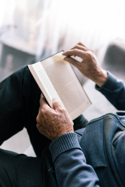 istock Hands of elderly man holding a book 2181287728