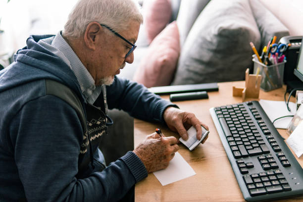 Senior man writing at his desk in home office