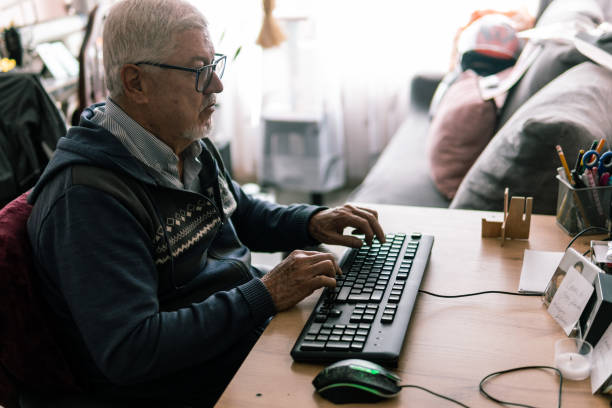 istock Elderly man focused on typing in a home workspace 2181288365