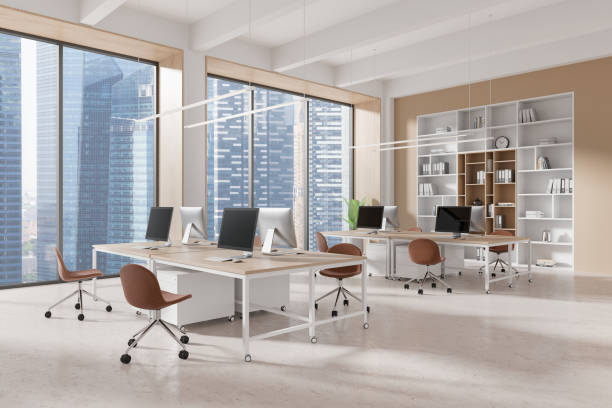 istock Beige coworking interior with tables and pc monitors, panoramic window 2181288429