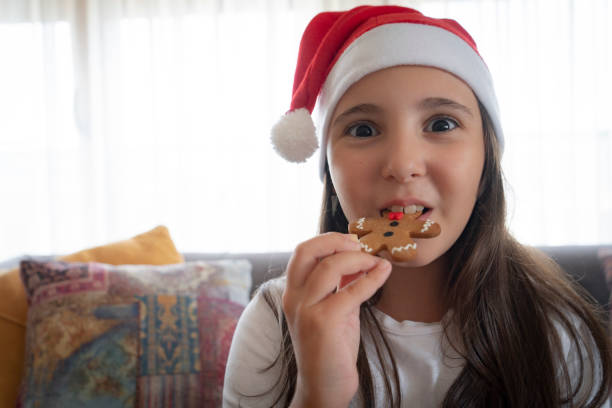 istock Portrait smiling girl eating gingerbread cookie 2181289239