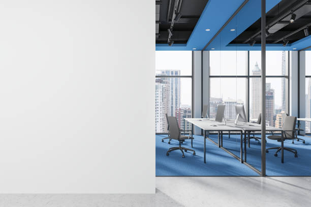 istock Colored office coworking interior with pc monitors in row, window. Mockup wall 2181290354