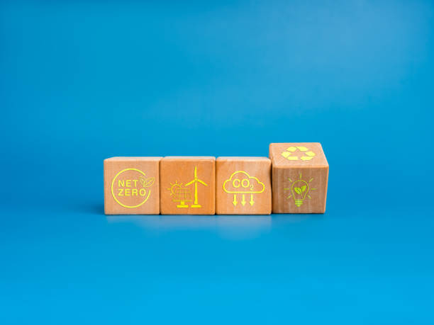 istock Net Zero icon and green renewable energy symbol on wooden cube blocks isolated on blue background, minimal style. Environmental sustainability, Net zero carbon dioxide reduction concept. 2181291550